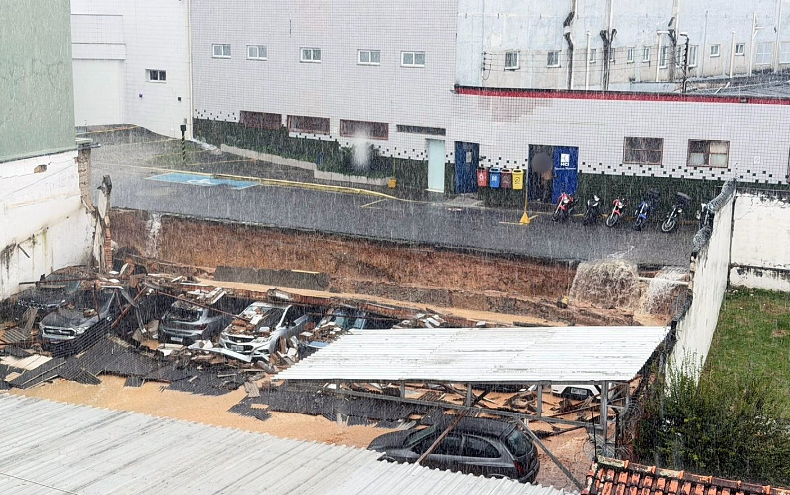 VÍDEO: Muro de estacionamento desaba durante chuva em Itajubá e mulher quase é atingida